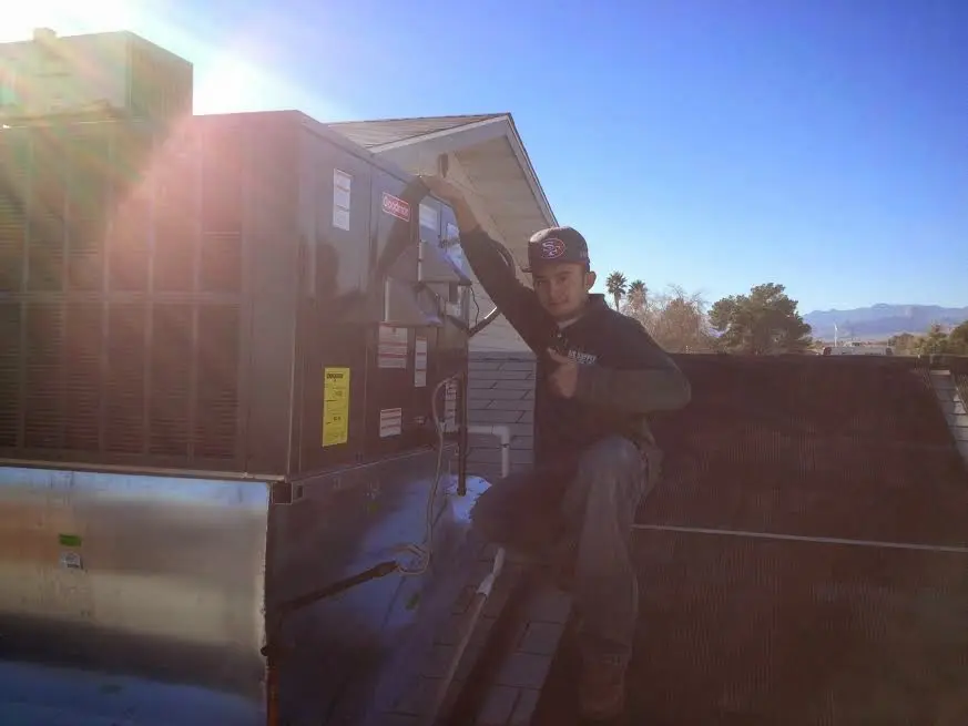 HVAC technician performing HVAC Inspection on a rooftop unit in El Campo